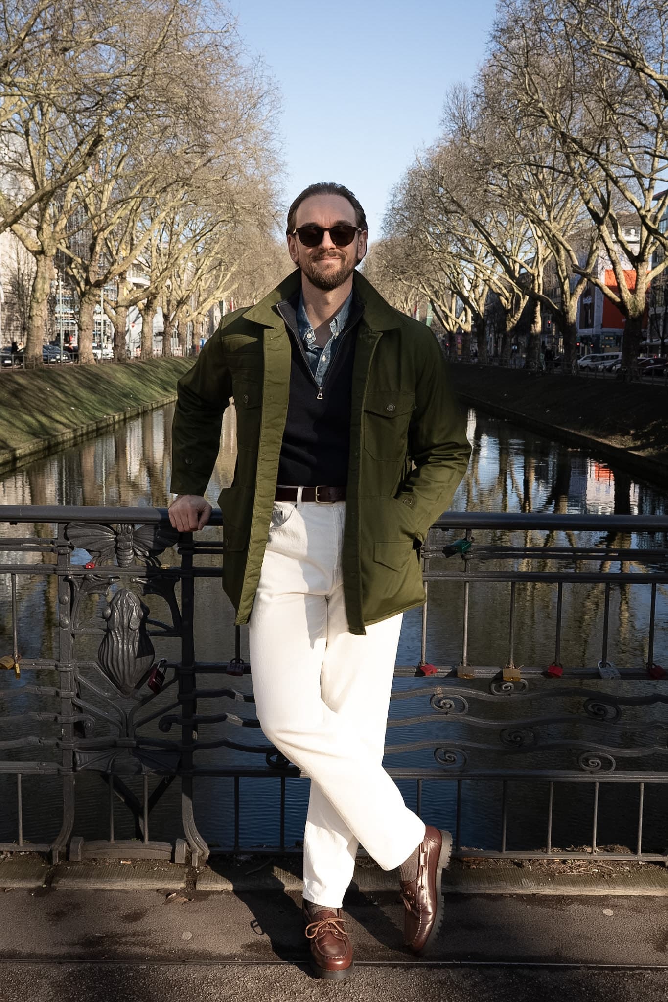 Marvin in grüner Field Jacket und weißer Jeans auf einer Brücke an der Kö in Düsseldorf