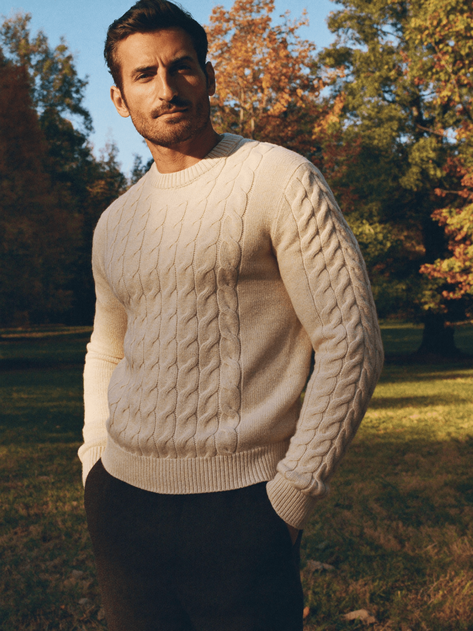 Marvin im cremefarbenen Zopfstrick im herbstlichen Park