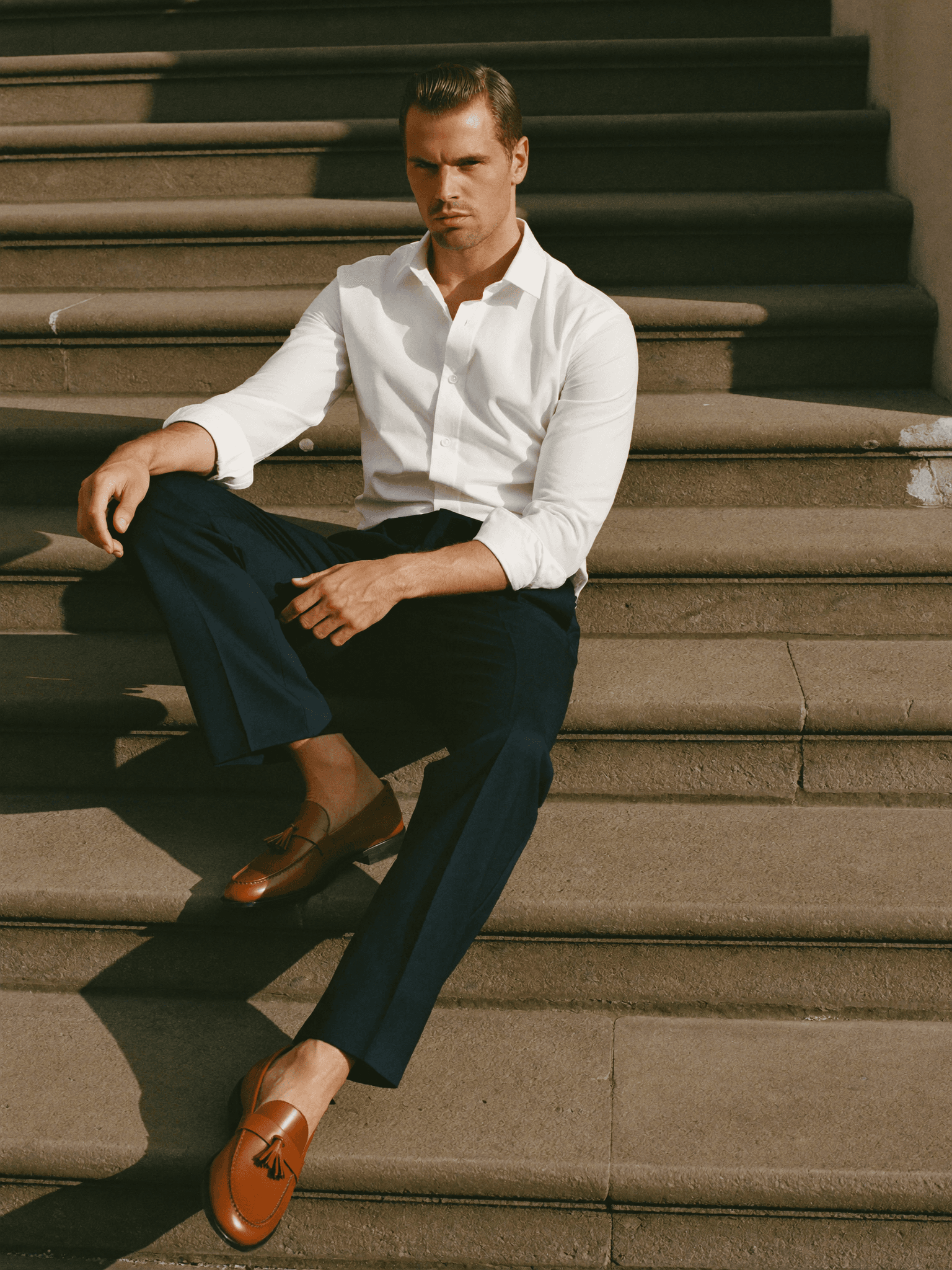 Marvin sitzend mit Loafern und navyfarbener Hose