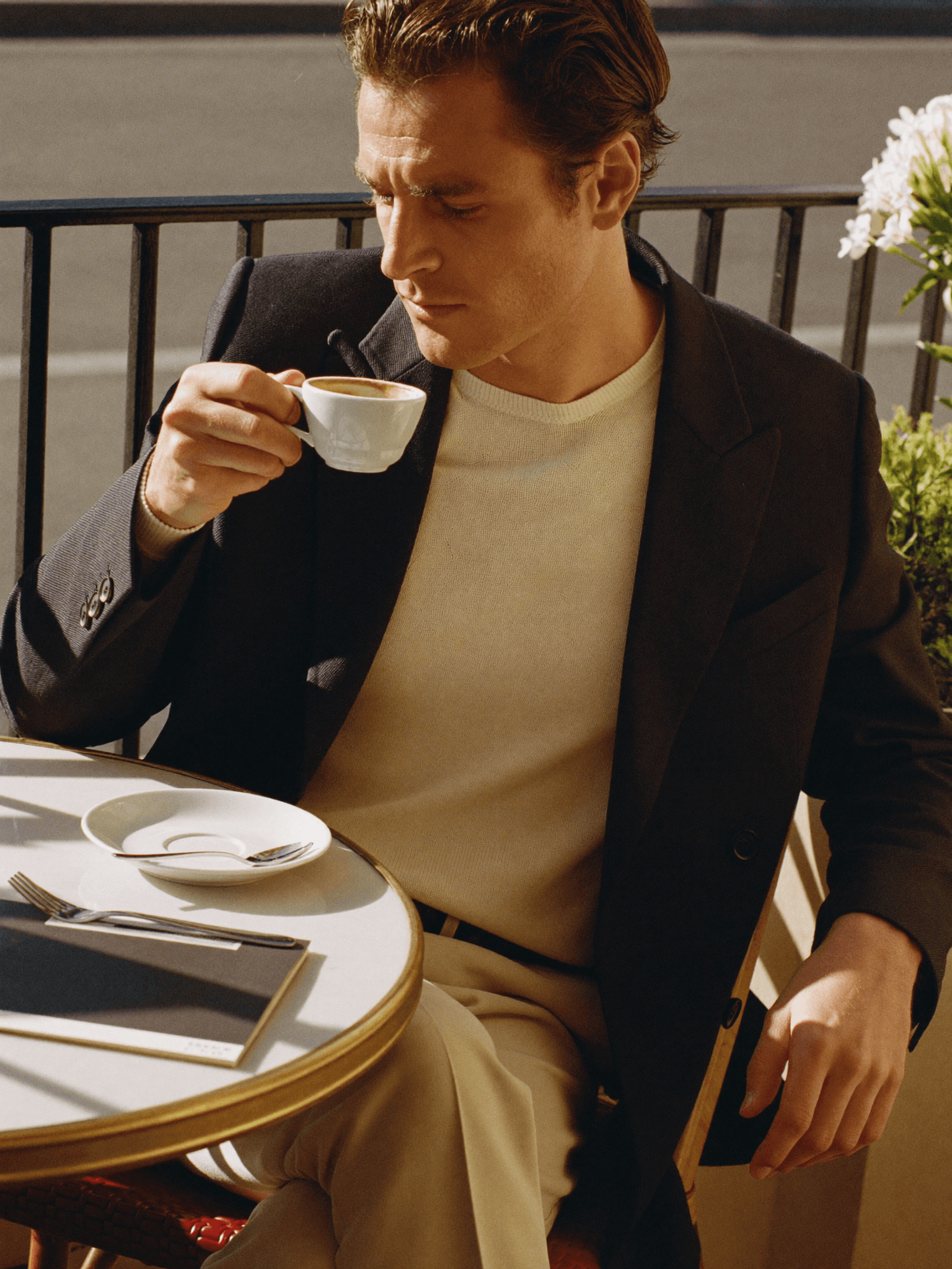 Marvin im Sakko über cremefarbenem Strick im Café